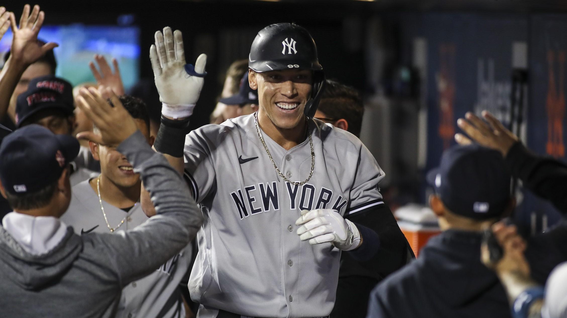 Yankees right fielder Aaron Judge (99) is greeted in the dugout after hitting a solo home run in the second inning against the New York Mets at Citi Field. / Wendell Cruz-USA TODAY Sports