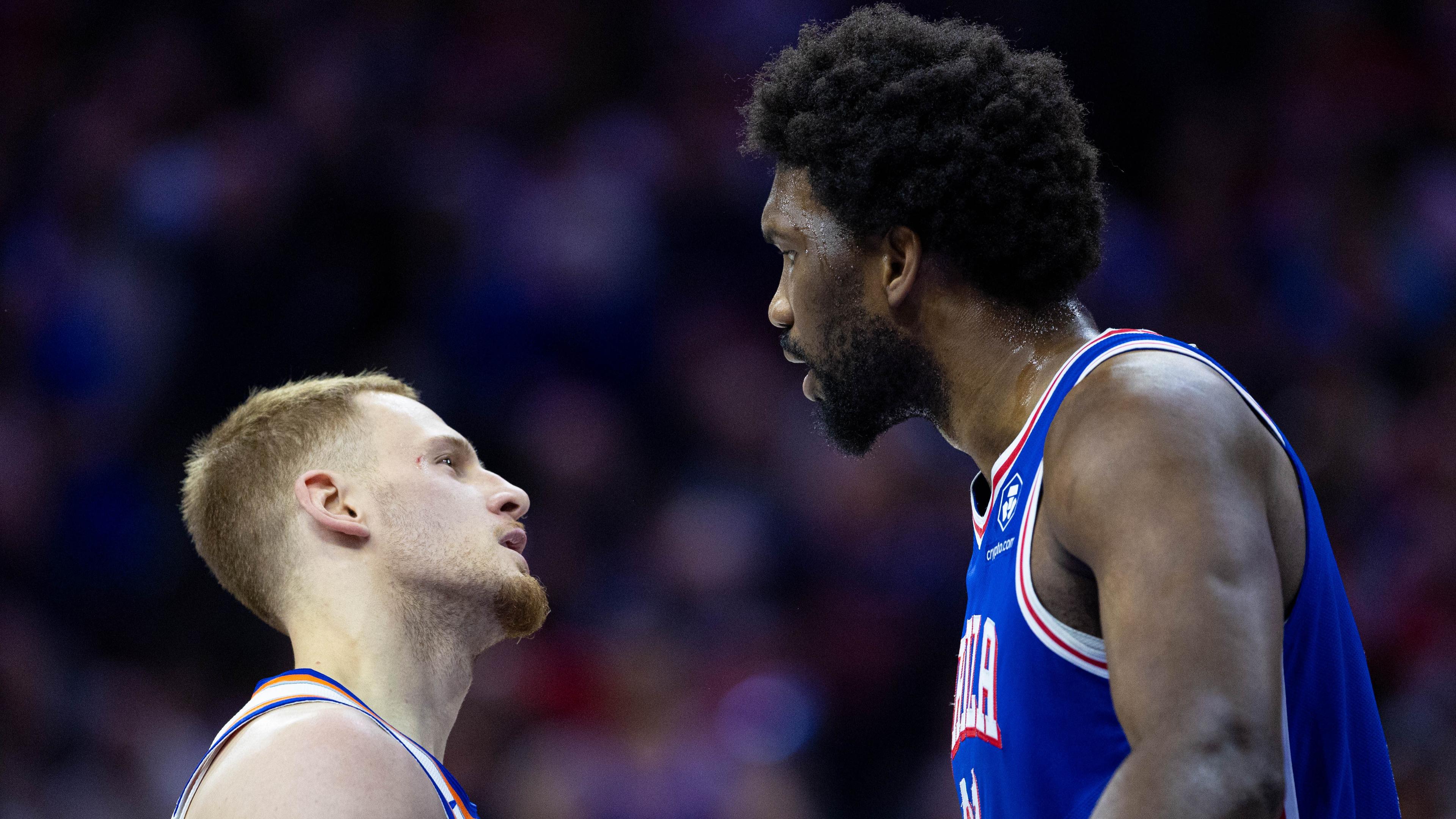 Apr 25, 2024; Philadelphia, Pennsylvania, USA; Philadelphia 76ers center Joel Embiid (21) has words with New York Knicks guard Donte DiVincenzo (L) after a play during the first quarter of game three of the first round for the 2024 NBA playoffs at Wells Fargo Center. Mandatory Credit: Bill Streicher-USA TODAY Sports / © Bill Streicher-USA TODAY Sports