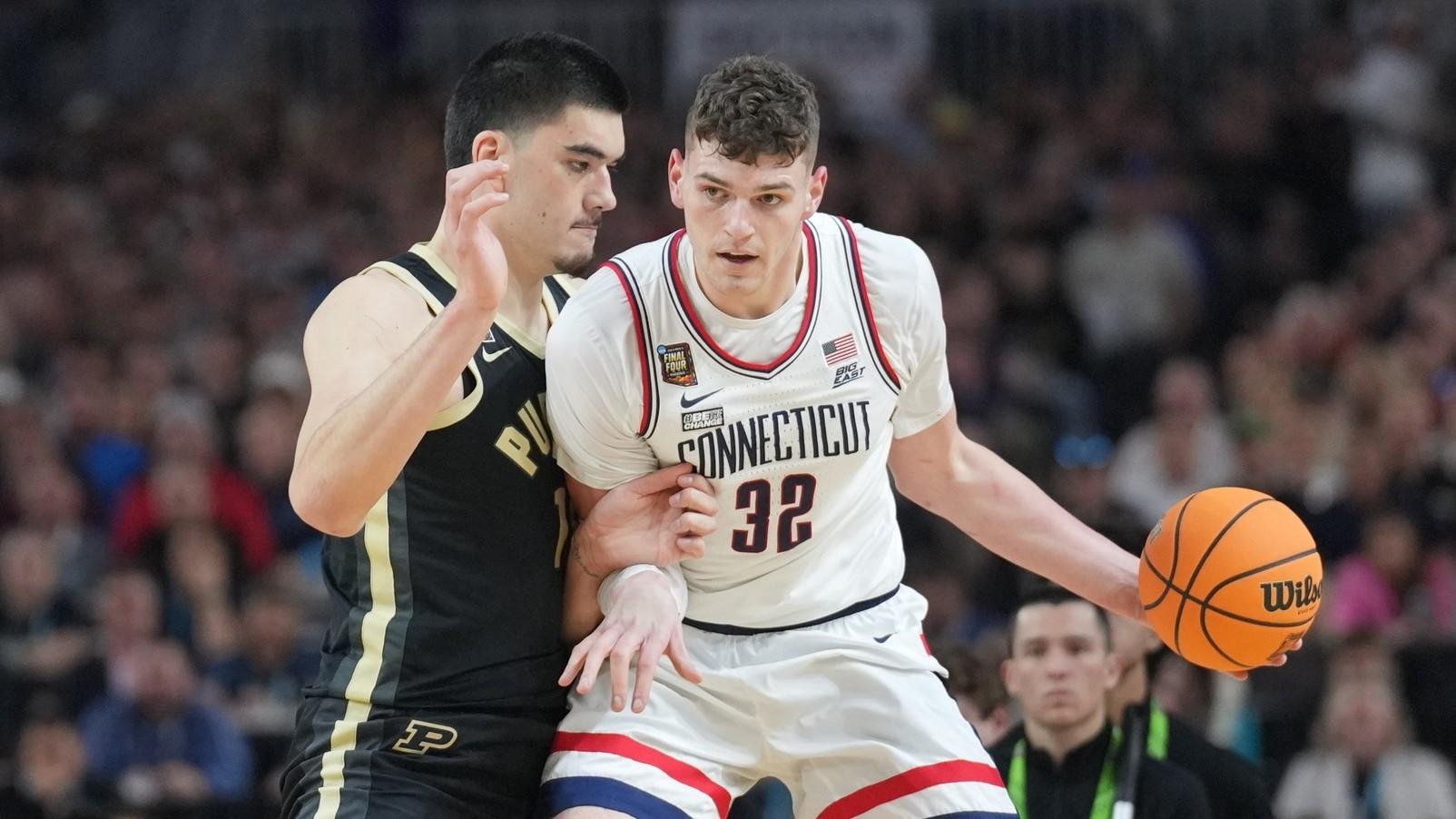 Connecticut Huskies center Donovan Clingan (32) dribbles against Purdue Boilermakers center Zach Edey (15) in the national championship game of the Final Four of the 2024 NCAA Tournament at State Farm Stadium. / Robert Deutsch-USA TODAY Sports