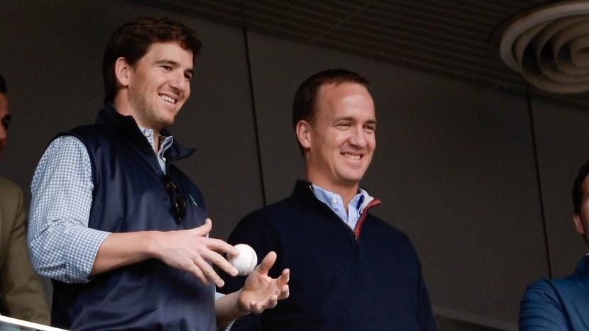 New York Giants quarterback Eli Manning and Denver Broncos quarterback Peyton Manning watch the game between the New York Yankees and Tampa Bay Rays at Yankee Stadium. / Robert Deutsch-USA TODAY Sports