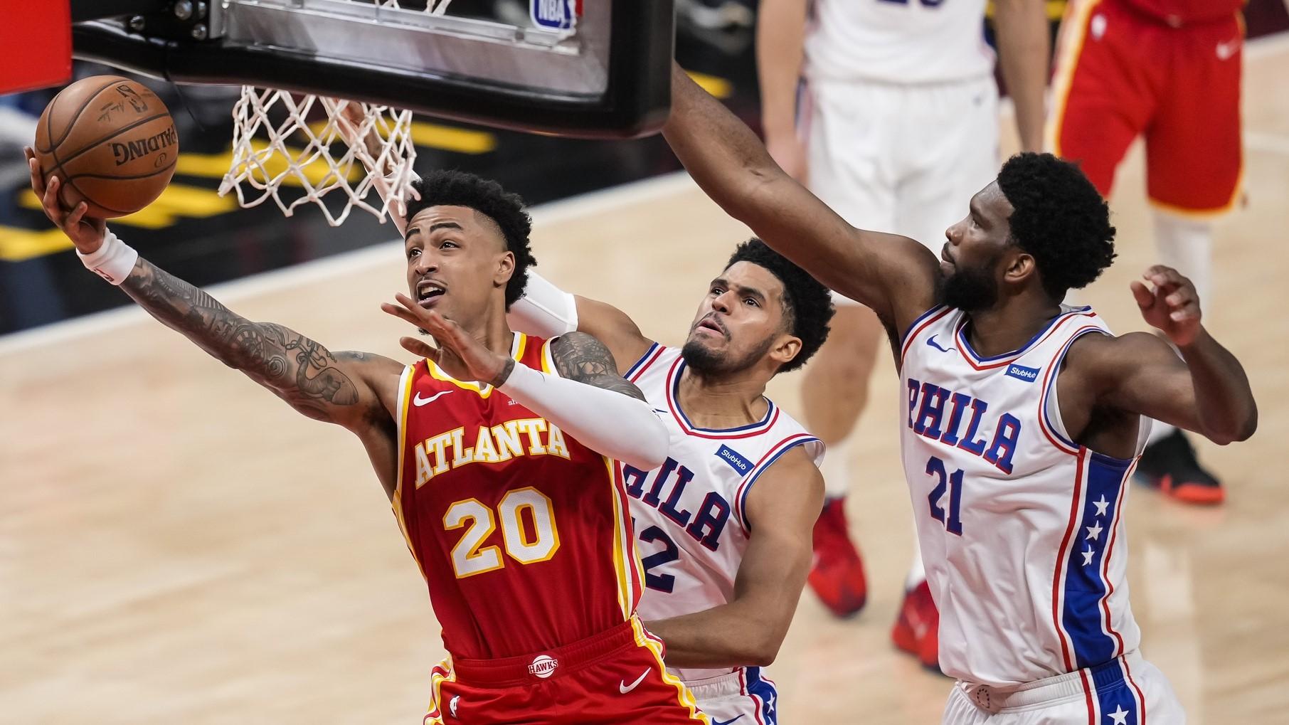 Atlanta Hawks forward John Collins (20) goes to the basket behind Philadelphia 76ers forward Tobias Harris (12) and center Joel Embiid (21) during the second half of game three in the second round of the 2021 NBA Playoffs. at State Farm Arena. / Dale Zanine-USA TODAY Sports